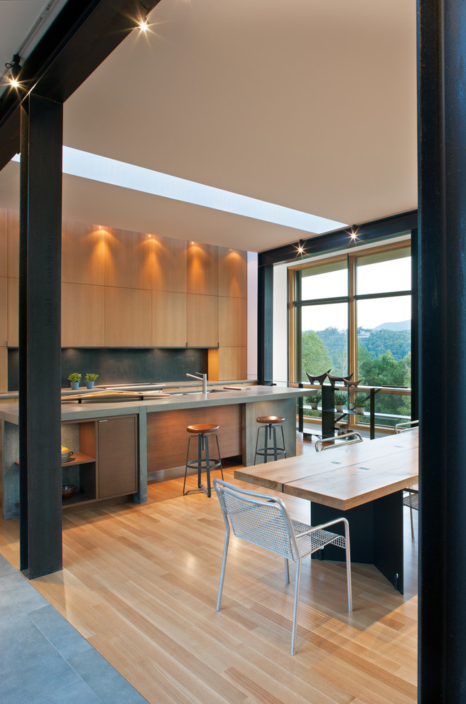 Ispirazione per una cucina minimalista con ante lisce, ante in legno chiaro, lavello integrato, paraspruzzi con piastrelle di metallo, parquet chiaro, pavimento beige, top in cemento, paraspruzzi nero e top grigio