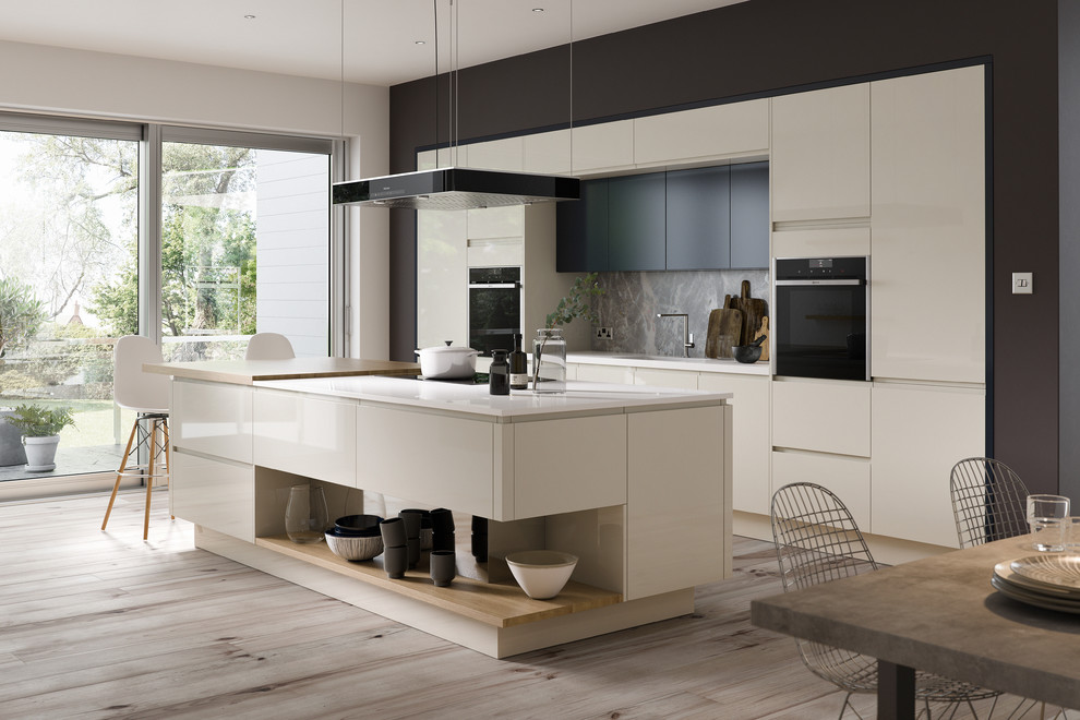 Large modern single-wall open plan kitchen in Other with an integrated sink, shaker cabinets, white cabinets, marble worktops, multi-coloured splashback, stone slab splashback, black appliances, dark hardwood flooring, an island and brown floors.