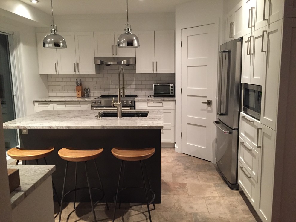 Mid-sized minimalist l-shaped ceramic tile and beige floor enclosed kitchen photo in Montreal with an undermount sink, shaker cabinets, white cabinets, quartzite countertops, white backsplash, ceramic backsplash, stainless steel appliances and an island