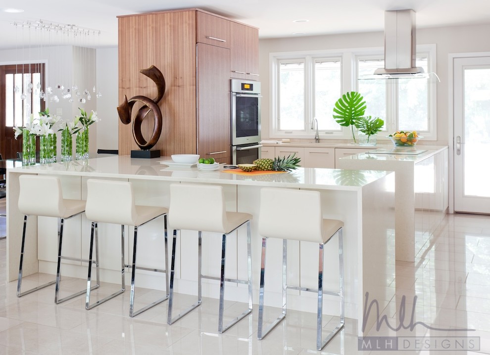 Example of a large minimalist u-shaped porcelain tile eat-in kitchen design in Little Rock with an undermount sink, flat-panel cabinets, beige cabinets, quartz countertops, paneled appliances and a peninsula