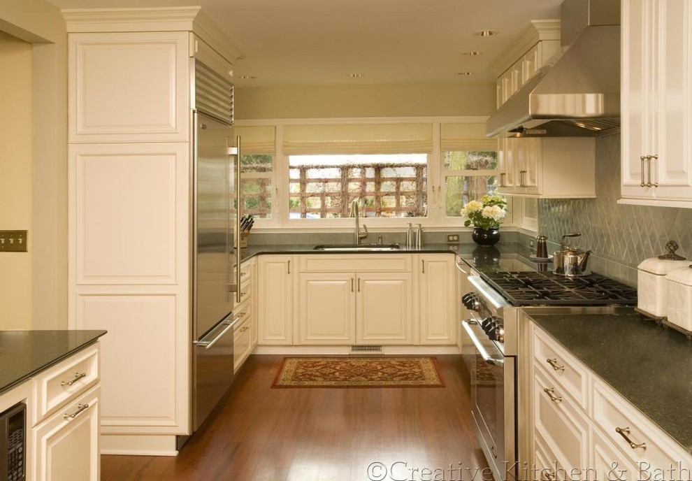 Example of a mid-sized classic dark wood floor enclosed kitchen design in Seattle with a single-bowl sink, raised-panel cabinets, white cabinets, granite countertops, ceramic backsplash, stainless steel appliances and no island