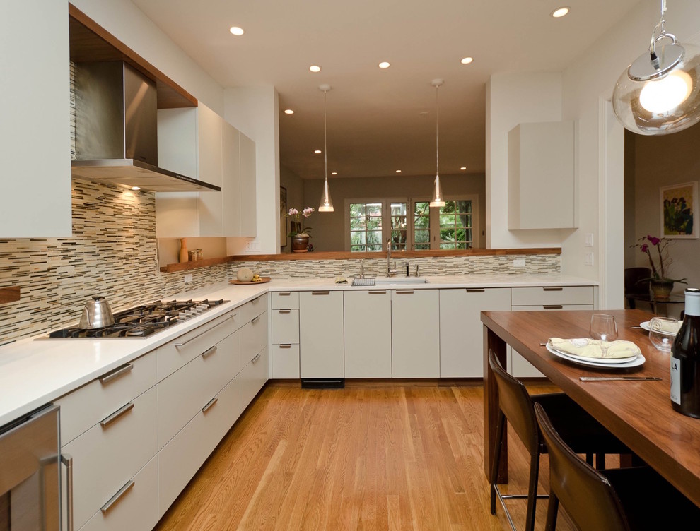 Example of a mid-sized trendy u-shaped medium tone wood floor and brown floor open concept kitchen design in Philadelphia with an undermount sink, flat-panel cabinets, gray cabinets, quartz countertops, glass tile backsplash, multicolored backsplash, stainless steel appliances and no island