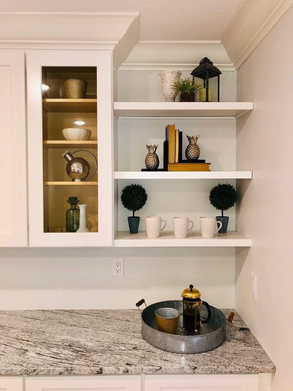 Foto på ett mellanstort retro grå kök, med en rustik diskho, skåp i shakerstil, vita skåp, granitbänkskiva, grått stänkskydd, stänkskydd i keramik, rostfria vitvaror, mellanmörkt trägolv, en köksö och brunt golv