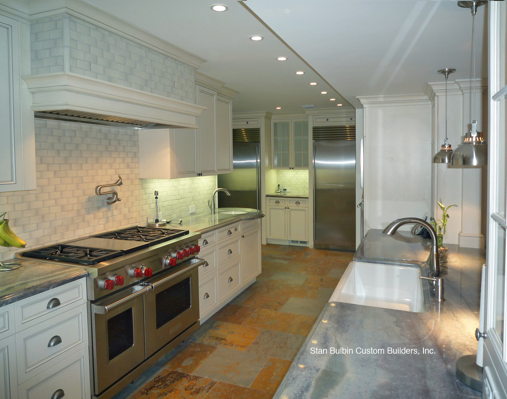 マイアミにある広いトラディショナルスタイルのおしゃれなキッチン (アンダーカウンターシンク、インセット扉のキャビネット、白いキャビネット、珪岩カウンター、白いキッチンパネル、サブウェイタイルのキッチンパネル、シルバーの調理設備、スレートの床、グレーの床) の写真