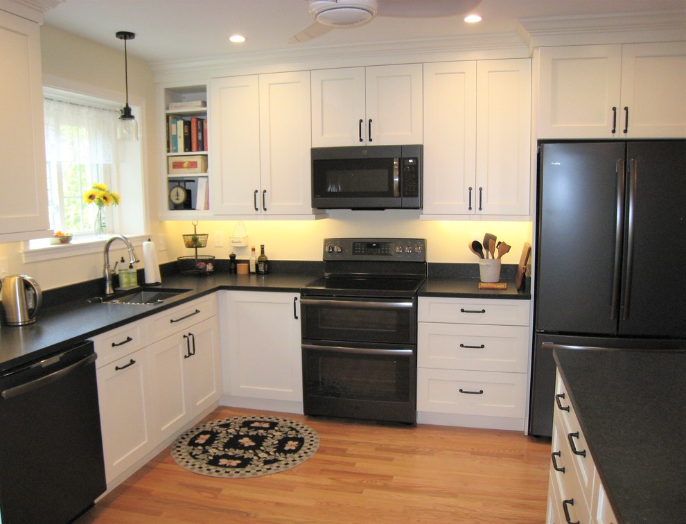 Idéer för ett mellanstort klassiskt grå u-kök, med en undermonterad diskho, skåp i shakerstil, vita skåp, granitbänkskiva, grått stänkskydd, ljust trägolv, en halv köksö och beiget golv