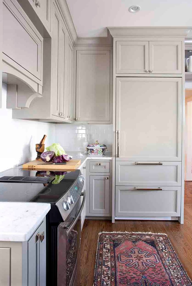 Inspiration for a small timeless u-shaped medium tone wood floor enclosed kitchen remodel in Atlanta with a farmhouse sink, recessed-panel cabinets, gray cabinets, marble countertops, white backsplash, subway tile backsplash, paneled appliances and no island