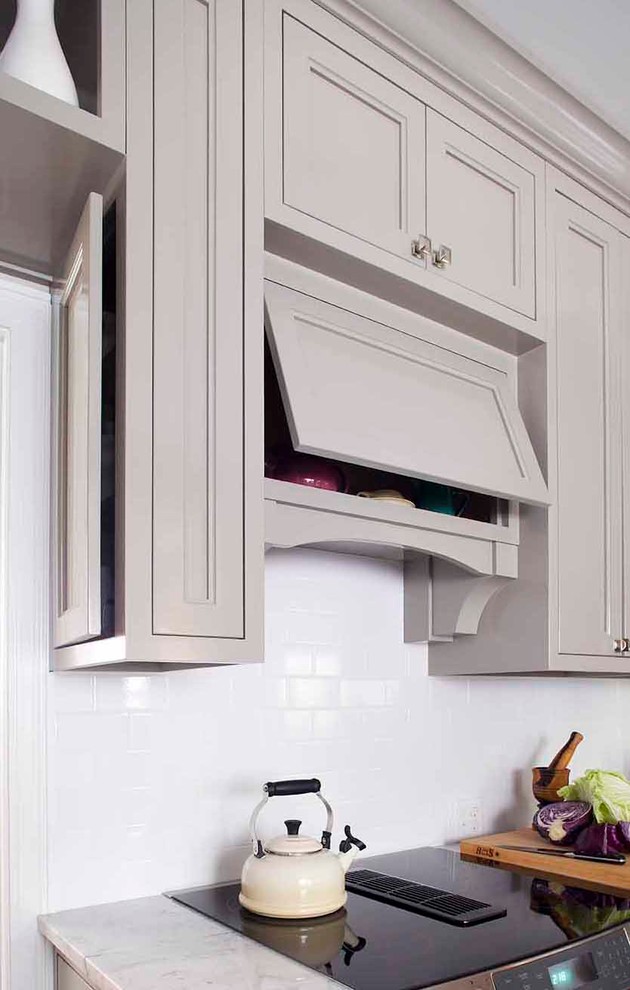 Enclosed kitchen - small traditional u-shaped medium tone wood floor enclosed kitchen idea in Atlanta with a farmhouse sink, recessed-panel cabinets, gray cabinets, marble countertops, white backsplash, subway tile backsplash, paneled appliances and no island