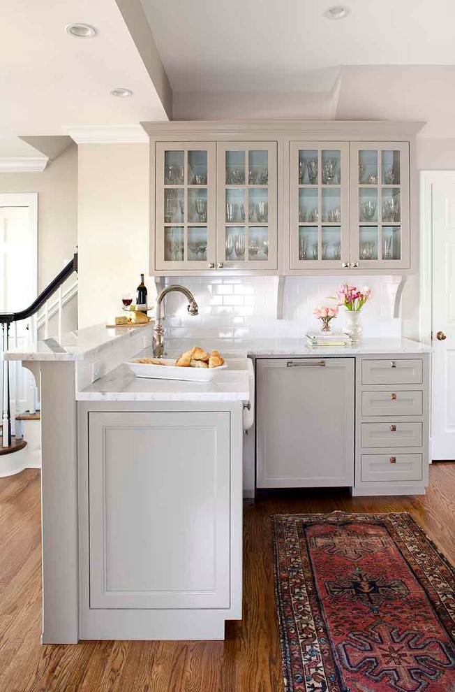 Photo of a small traditional u-shaped enclosed kitchen in Atlanta with a belfast sink, recessed-panel cabinets, grey cabinets, marble worktops, white splashback, metro tiled splashback, integrated appliances, medium hardwood flooring and no island.