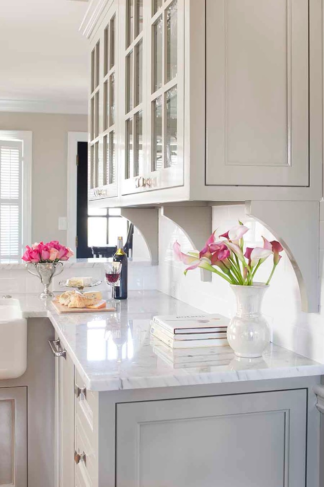 Example of a small classic u-shaped medium tone wood floor enclosed kitchen design in Atlanta with a farmhouse sink, recessed-panel cabinets, gray cabinets, marble countertops, white backsplash, subway tile backsplash and paneled appliances