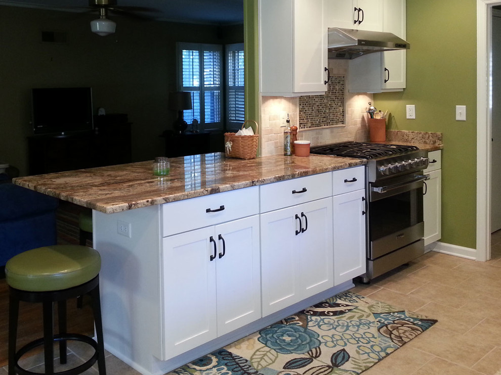 Exempel på ett klassiskt kök, med en nedsänkt diskho, luckor med infälld panel, vita skåp, granitbänkskiva, beige stänkskydd och rostfria vitvaror
