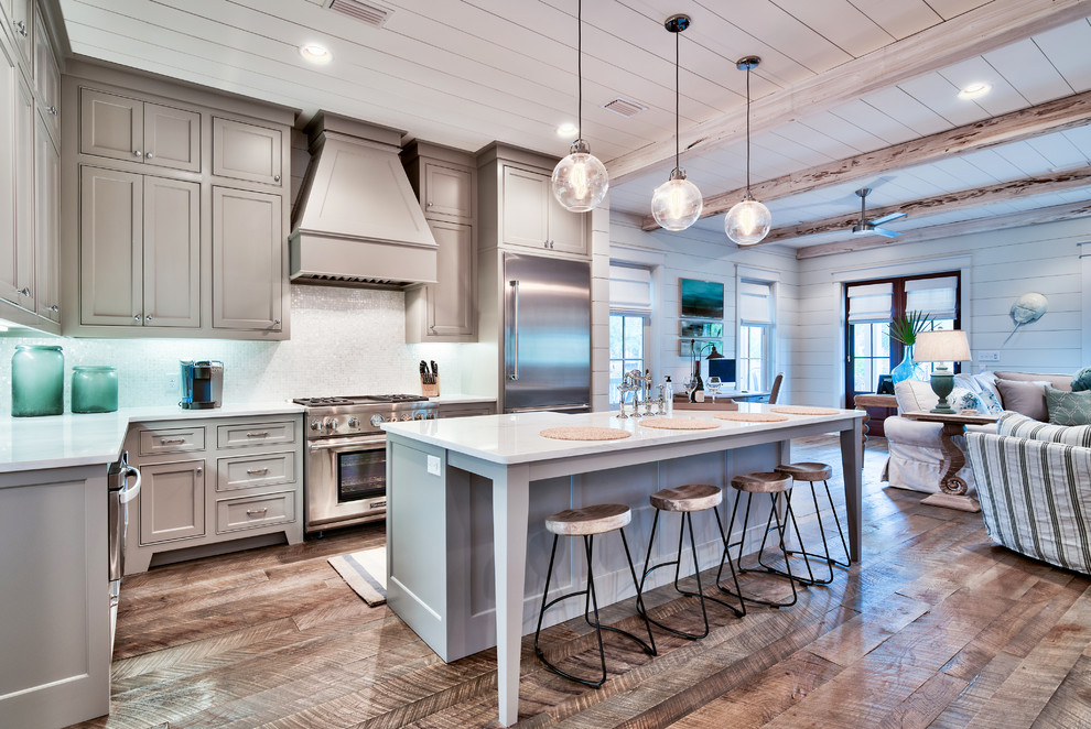 Design ideas for a nautical l-shaped open plan kitchen in Miami with recessed-panel cabinets, stainless steel appliances, medium hardwood flooring and an island.