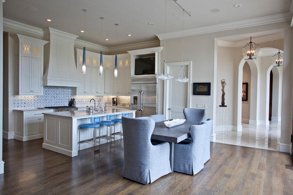 Exempel på ett stort medelhavsstil vit vitt kök, med en undermonterad diskho, luckor med infälld panel, vita skåp, granitbänkskiva, blått stänkskydd, stänkskydd i keramik, rostfria vitvaror, mellanmörkt trägolv, en köksö och brunt golv