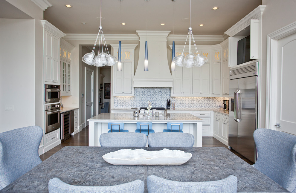 Inspiration for a large mediterranean u-shaped medium tone wood floor and brown floor eat-in kitchen remodel in Other with an undermount sink, recessed-panel cabinets, white cabinets, granite countertops, blue backsplash, ceramic backsplash, stainless steel appliances, an island and white countertops