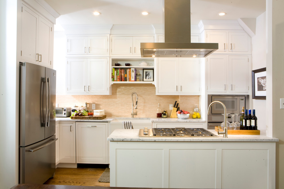 Klassisk inredning av ett u-kök, med rostfria vitvaror, en rustik diskho, skåp i shakerstil, vita skåp, marmorbänkskiva och beige stänkskydd