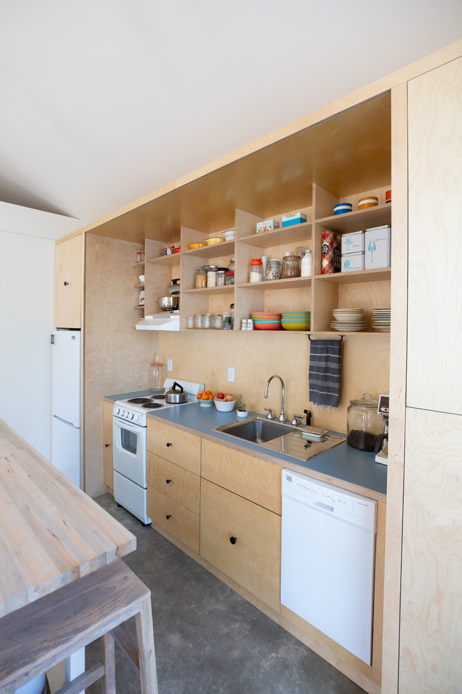 Cette photo montre une petite cuisine linéaire tendance en bois clair avec un évier posé, un placard à porte plane, un électroménager blanc, îlot, un sol gris et un plan de travail gris.