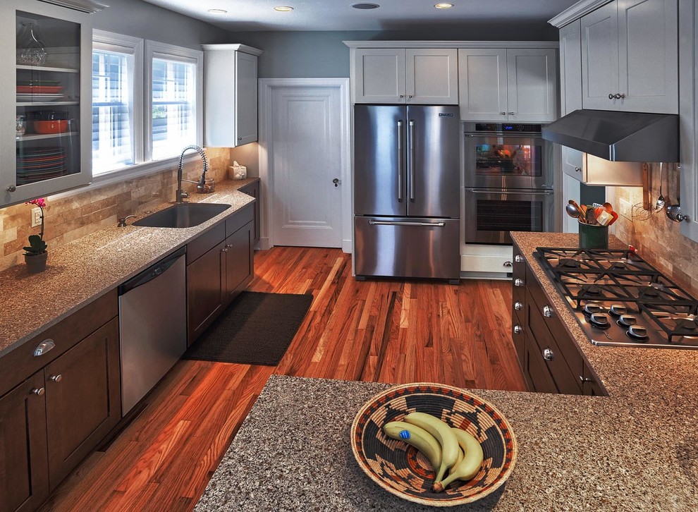 Example of a mid-sized classic u-shaped dark wood floor eat-in kitchen design in Other with a single-bowl sink, shaker cabinets, dark wood cabinets, laminate countertops, beige backsplash, ceramic backsplash, stainless steel appliances and a peninsula