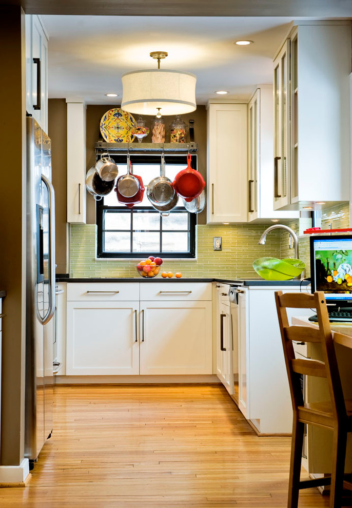 Geschlossene Stilmix Küche in U-Form mit Küchenrückwand in Grün, weißen Schränken, Schrankfronten im Shaker-Stil, Rückwand aus Glasfliesen und Küchengeräten aus Edelstahl in Sonstige