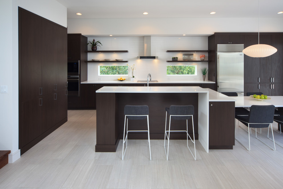 Moderne Wohnküche mit flächenbündigen Schrankfronten, dunklen Holzschränken, Küchenrückwand in Weiß, Küchengeräten aus Edelstahl und Kücheninsel in Orlando