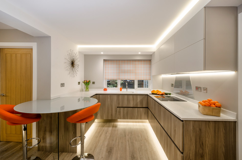 Inspiration for a contemporary laminate floor kitchen remodel in Devon with an integrated sink, flat-panel cabinets, gray cabinets, solid surface countertops and stainless steel appliances