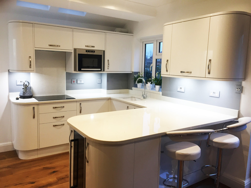 Immagine di una grande cucina abitabile minimalista con ante lisce, ante bianche, top in marmo, paraspruzzi grigio e paraspruzzi con lastra di vetro