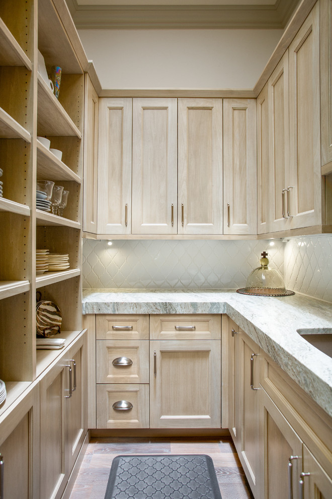 Amerikansk inredning av ett mellanstort beige beige kök, med en rustik diskho, luckor med infälld panel, skåp i ljust trä, bänkskiva i kvartsit, vitt stänkskydd, stänkskydd i keramik, integrerade vitvaror, mellanmörkt trägolv, en köksö och brunt golv