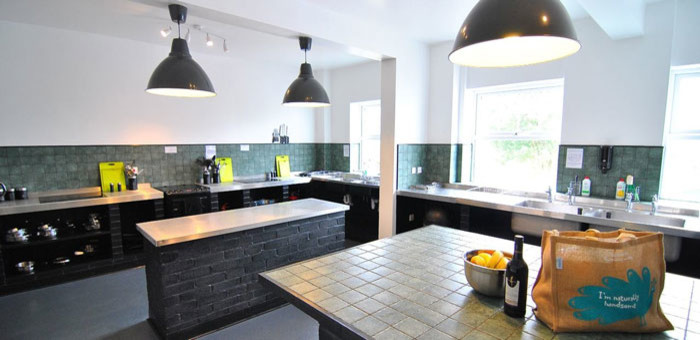 Exempel på ett stort rustikt kök, med en dubbel diskho, öppna hyllor, bänkskiva i rostfritt stål, grönt stänkskydd, flera köksöar, stänkskydd i keramik, rostfria vitvaror, linoleumgolv och grått golv