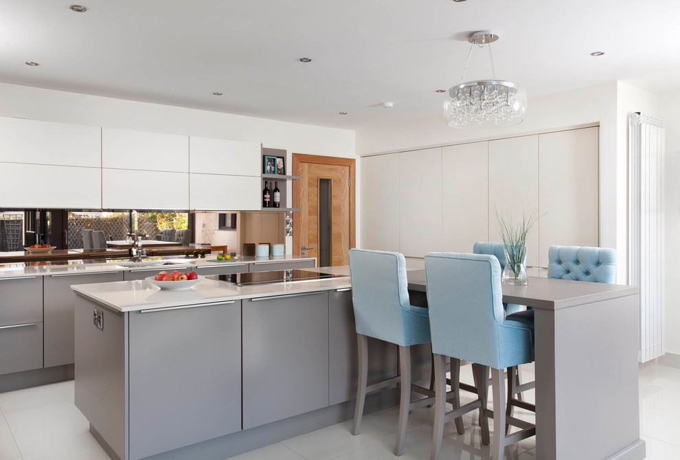 This is an example of a medium sized contemporary u-shaped open plan kitchen in Dublin with an integrated sink, flat-panel cabinets, grey cabinets, quartz worktops, grey splashback, glass sheet splashback, black appliances, cement flooring and an island.