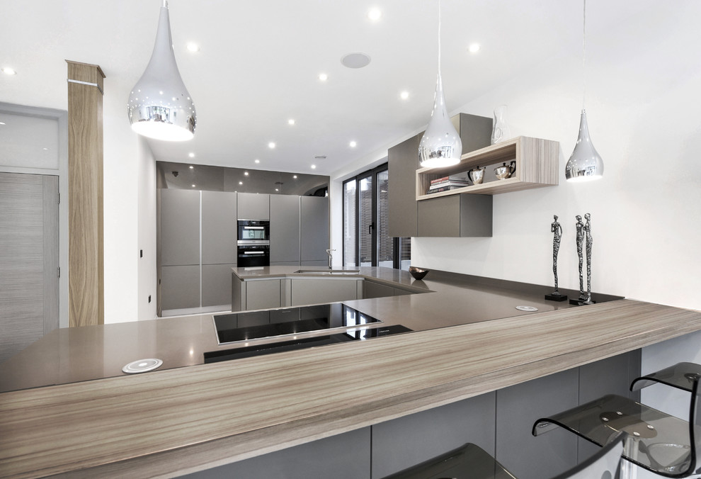 Inspiration for a large contemporary open plan kitchen in London with a submerged sink, glass-front cabinets, grey cabinets, composite countertops, no island, grey floors and grey worktops.