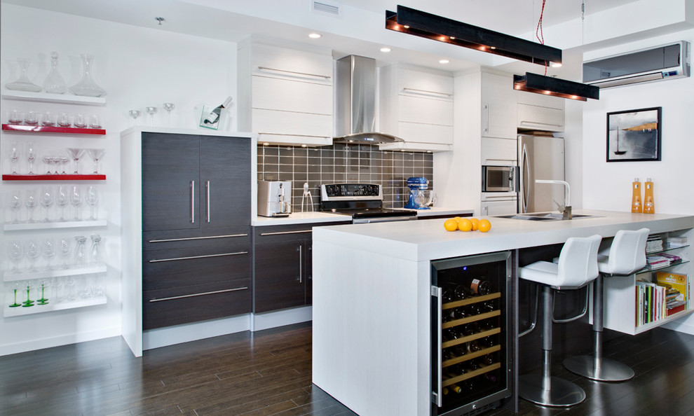 Small modern single-wall open plan kitchen in Montreal with an island, flat-panel cabinets, white cabinets, a double-bowl sink, laminate countertops, grey splashback, ceramic splashback, stainless steel appliances and dark hardwood flooring.