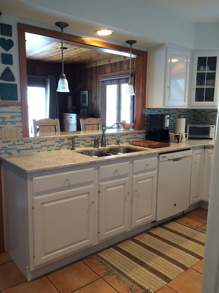 Bild på ett mellanstort maritimt kök, med en undermonterad diskho, luckor med upphöjd panel, vita skåp, bänkskiva i kvartsit, flerfärgad stänkskydd, stänkskydd i stickkakel, vita vitvaror, klinkergolv i keramik och en köksö