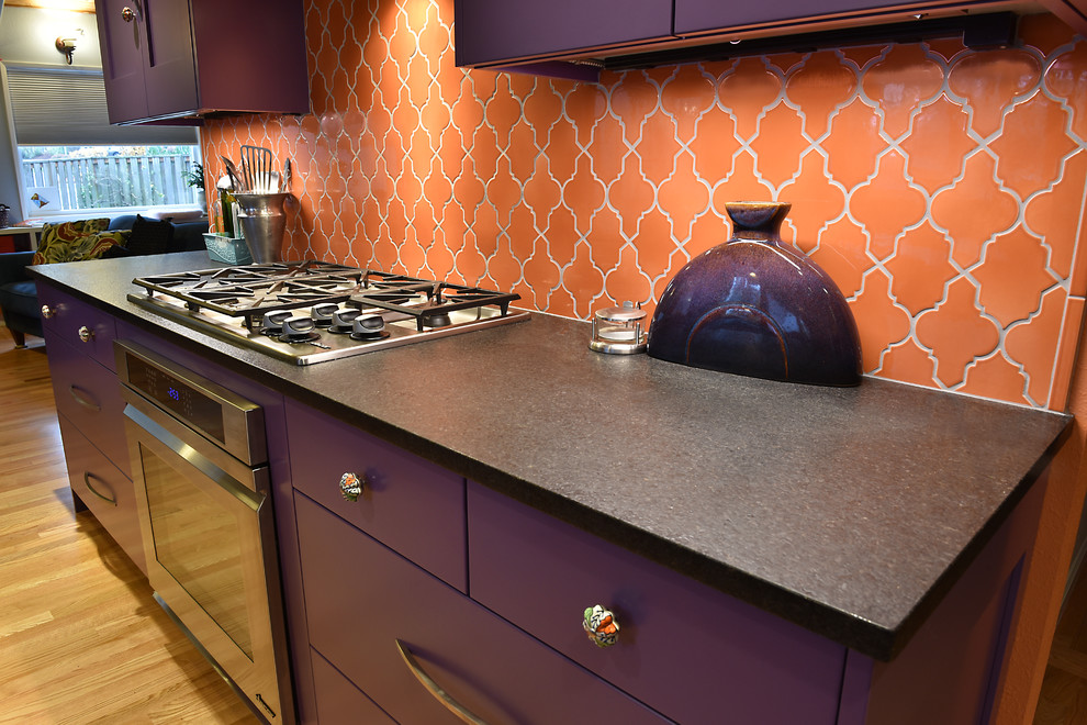 Exempel på ett avskilt, stort medelhavsstil svart svart l-kök, med en undermonterad diskho, skåp i shakerstil, lila skåp, bänkskiva i kvarts, orange stänkskydd, stänkskydd i keramik, rostfria vitvaror, ljust trägolv, en köksö och brunt golv