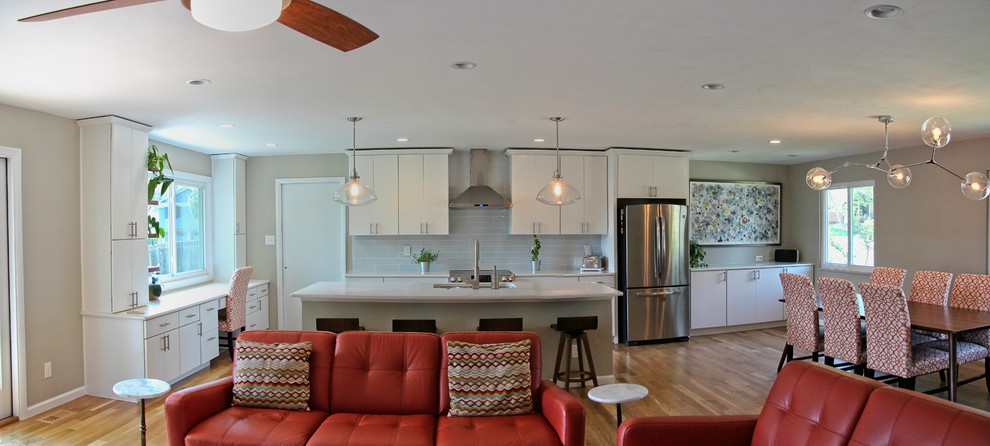 Inspiration for a large contemporary l-shaped kitchen in Denver with white cabinets, stainless steel appliances, an island and white worktops.