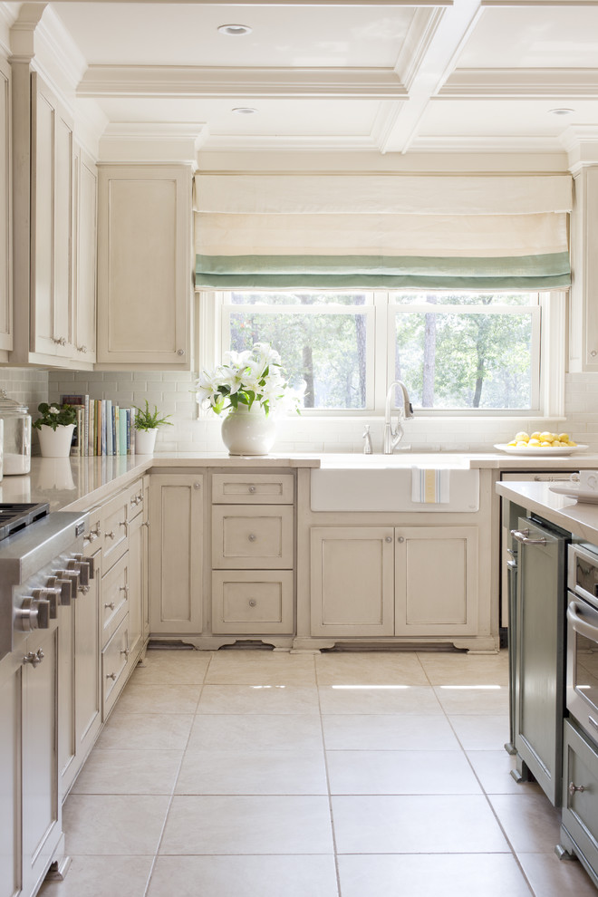 Mid-sized transitional u-shaped eat-in kitchen photo in Little Rock with a farmhouse sink, recessed-panel cabinets, beige cabinets, quartz countertops, white backsplash, subway tile backsplash, paneled appliances and an island