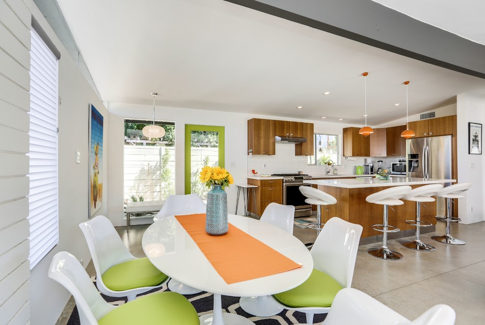 Inspiration for a mid-sized 1960s ceramic tile eat-in kitchen remodel in Los Angeles with a double-bowl sink, flat-panel cabinets, light wood cabinets, soapstone countertops, white backsplash, mosaic tile backsplash, stainless steel appliances and an island