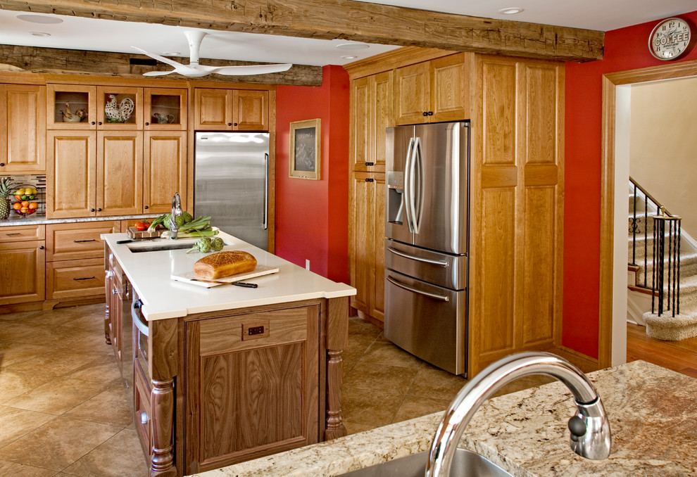 Lantlig inredning av ett stort kök, med en undermonterad diskho, luckor med upphöjd panel, skåp i mellenmörkt trä, granitbänkskiva, flerfärgad stänkskydd, stänkskydd i keramik, rostfria vitvaror, klinkergolv i keramik och en köksö