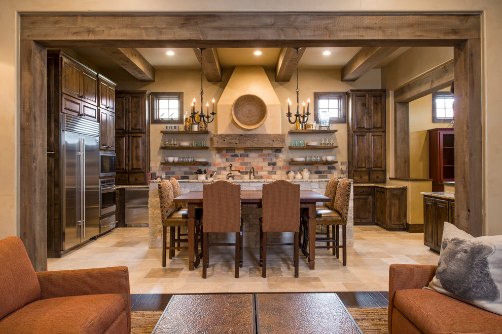 Rustikale Küche in U-Form mit profilierten Schrankfronten, dunklen Holzschränken, bunter Rückwand, Küchengeräten aus Edelstahl, Kücheninsel und beigem Boden in Austin