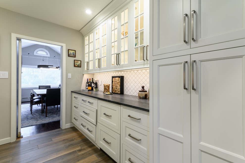 Idéer för att renovera ett stort vintage grå grått kök, med en rustik diskho, luckor med infälld panel, vita skåp, marmorbänkskiva, grått stänkskydd, stänkskydd i tunnelbanekakel, rostfria vitvaror, ljust trägolv, en köksö och brunt golv