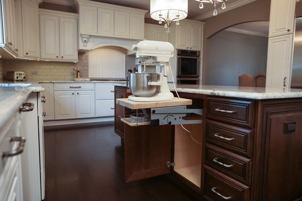 Photo of a large traditional u-shaped kitchen in Chicago with a double-bowl sink, raised-panel cabinets, white cabinets, granite worktops, grey splashback, metro tiled splashback, stainless steel appliances, dark hardwood flooring and an island.