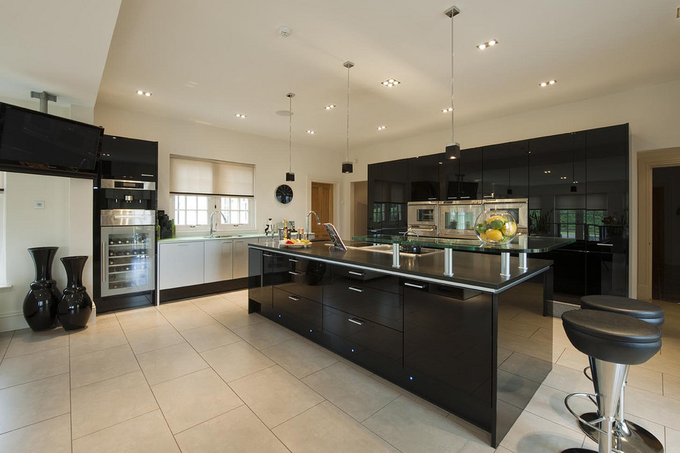 This is an example of a modern kitchen in Other with stainless steel appliances and beige floors.