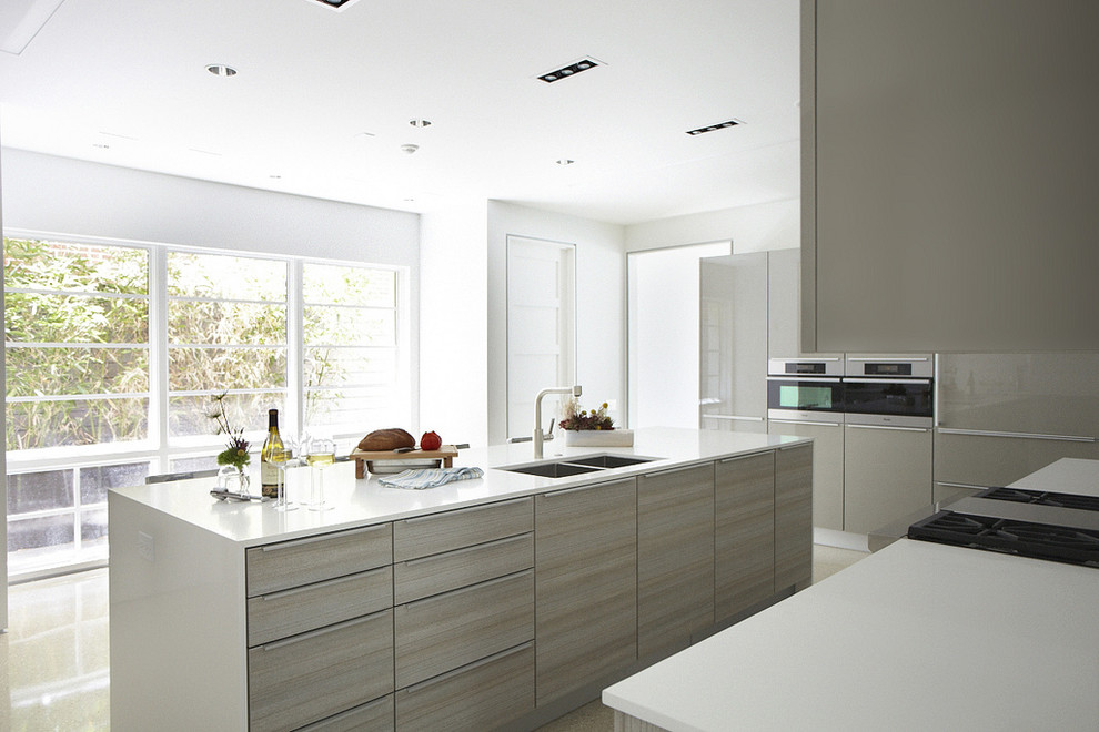 Ejemplo de cocina minimalista con fregadero de doble seno, armarios con paneles lisos y puertas de armario grises
