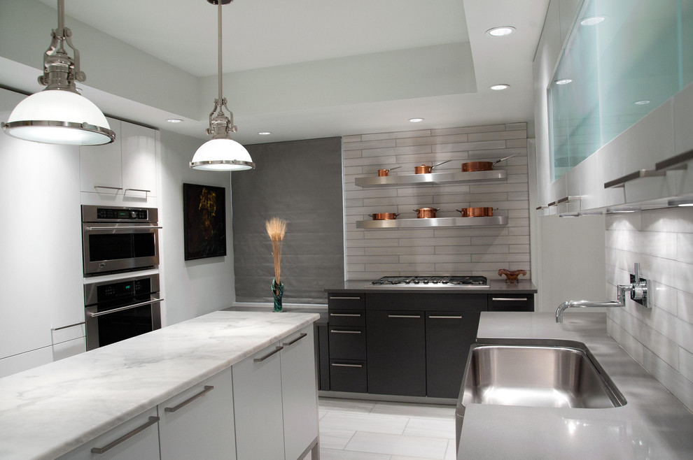 Exempel på ett modernt kök, med en undermonterad diskho, släta luckor, vita skåp och stänkskydd i marmor