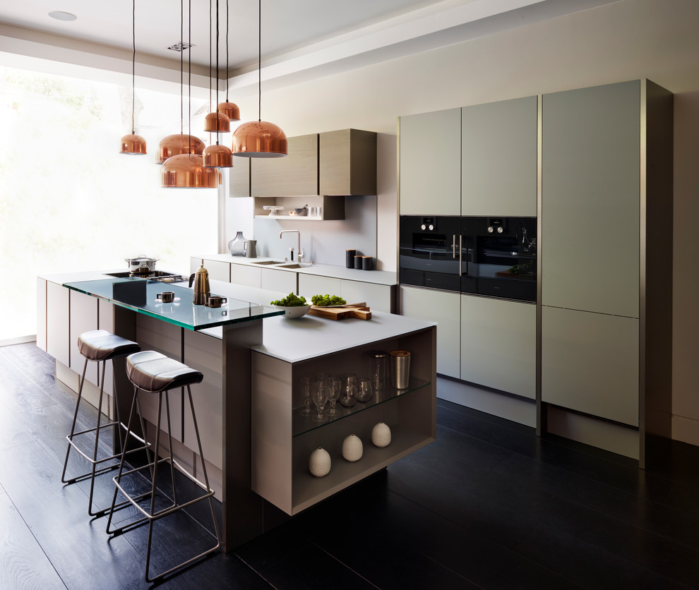 Einzeilige Moderne Küche mit flächenbündigen Schrankfronten, hellen Holzschränken, dunklem Holzboden und Kücheninsel in Kent