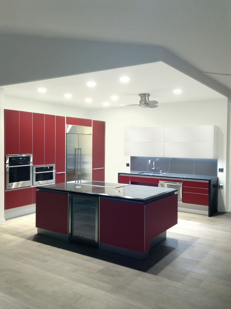Inspiration for a medium sized contemporary open plan kitchen in Hawaii with a submerged sink, flat-panel cabinets, red cabinets, granite worktops, metallic splashback, porcelain splashback, stainless steel appliances, porcelain flooring, an island, grey floors and black worktops.