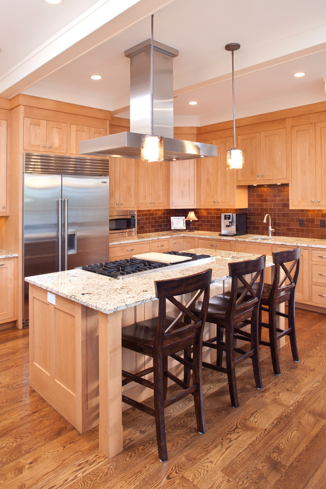Bild på ett mellanstort kök, med en integrerad diskho, luckor med profilerade fronter, skåp i ljust trä, granitbänkskiva, brunt stänkskydd, stänkskydd i keramik, mellanmörkt trägolv och en köksö