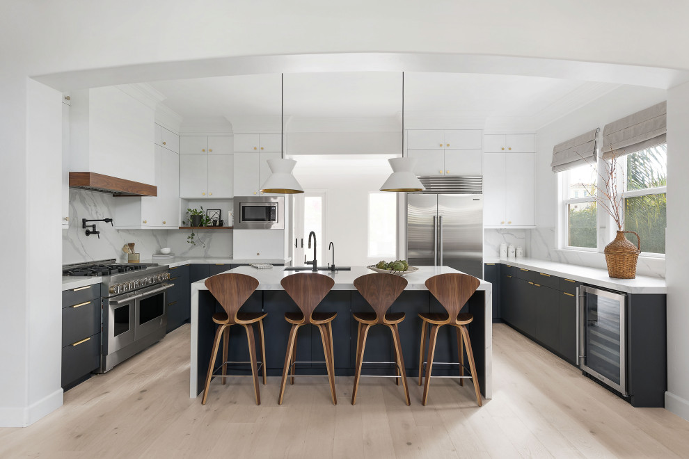 Contemporary u-shaped kitchen in San Diego with a submerged sink, flat-panel cabinets, grey cabinets, light hardwood flooring, an island, beige floors and white worktops.