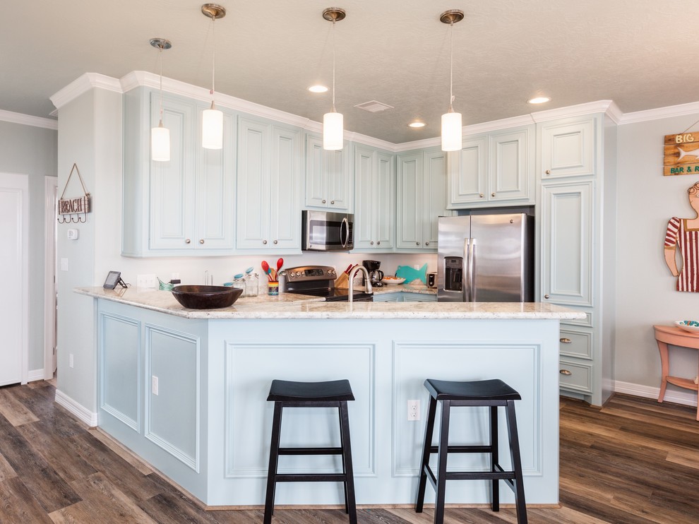 Example of a mid-sized beach style u-shaped dark wood floor and brown floor open concept kitchen design in Houston with beaded inset cabinets, blue cabinets, marble countertops, stainless steel appliances, a peninsula, beige backsplash and stone slab backsplash