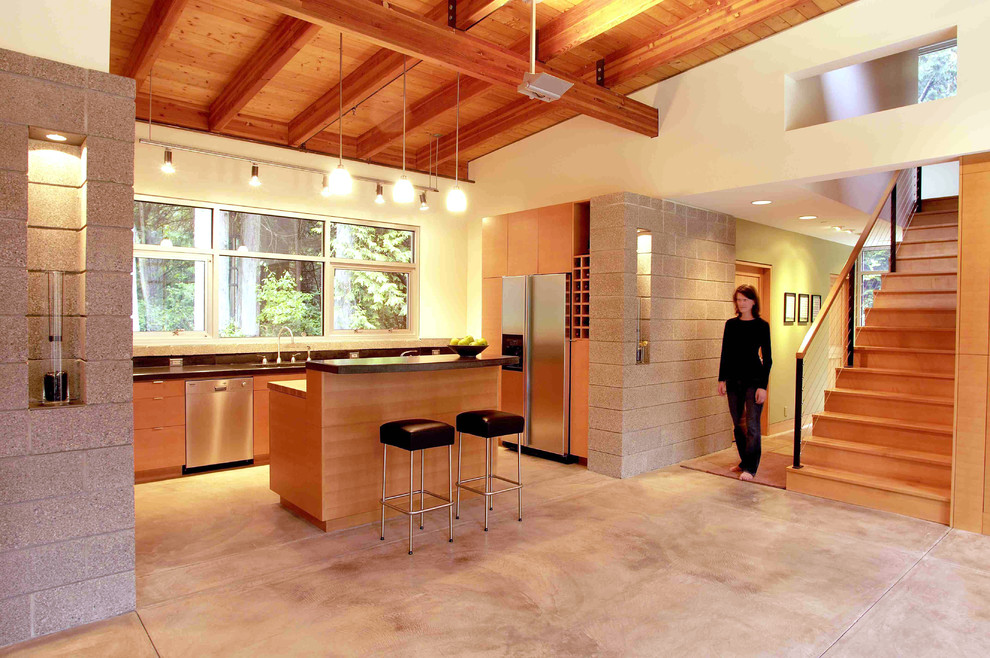 Moderne Küchenbar mit flächenbündigen Schrankfronten, hellbraunen Holzschränken und Küchengeräten aus Edelstahl in Seattle