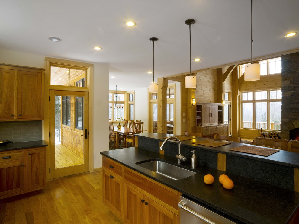 Exempel på ett stort rustikt kök, med en undermonterad diskho, en köksö, luckor med infälld panel, skåp i mellenmörkt trä, grått stänkskydd och rostfria vitvaror