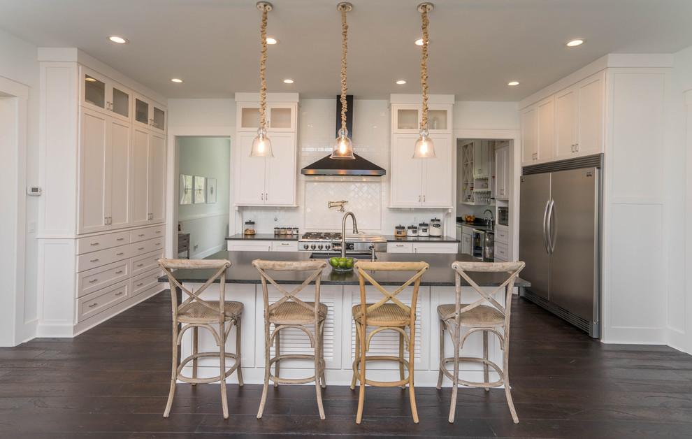 Example of a beach style galley dark wood floor and brown floor kitchen design in Atlanta with an undermount sink, recessed-panel cabinets, white cabinets, white backsplash, stainless steel appliances and an island
