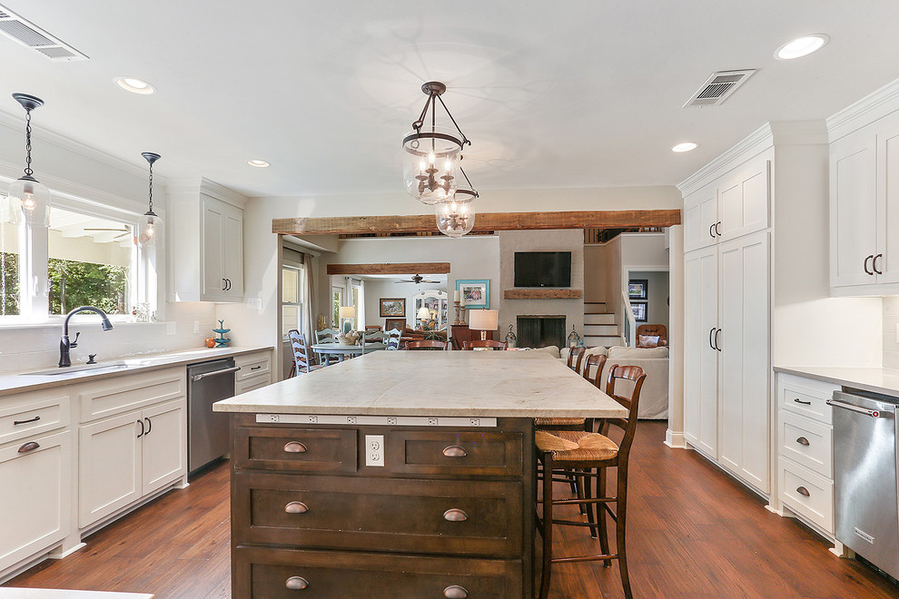 Inspiration for a large transitional medium tone wood floor and brown floor eat-in kitchen remodel in New Orleans with an undermount sink, shaker cabinets, white cabinets, quartzite countertops, white backsplash, subway tile backsplash, stainless steel appliances and an island